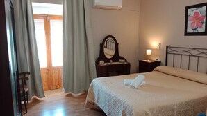 A hotel room with a bed, a bedside table, a mirror, an air conditioning unit, and a window with curtains. - Holiday Home 'Batalla Navas de Tolosa' with Mountain View, Pool & Wi-Fi (Santa Elena)