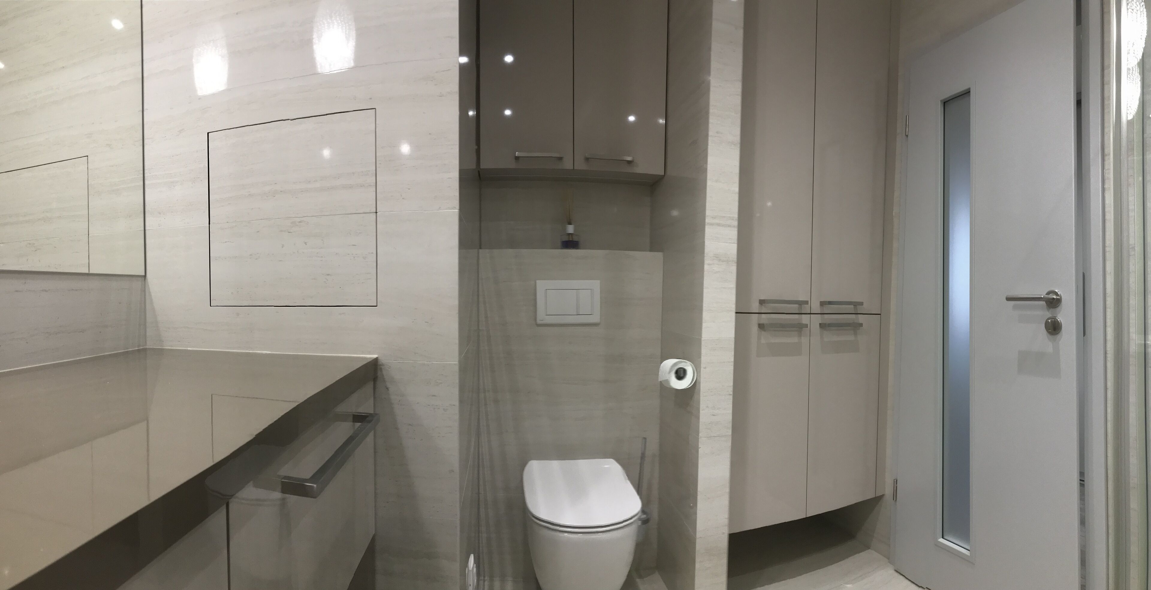 A modern bathroom with a toilet, a shower, and a sink.