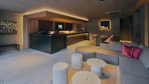 Eine moderne Hotelhalle mit Rezeption, Sitzbereich und Bar.