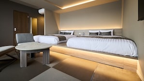 Ein modernes Hotelzimmer mit einem großen Bett, einer Sitzecke und einem kleinen Tisch.