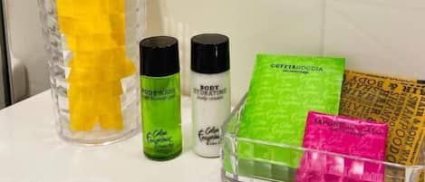 A bathroom with toiletries including body wash, body lotion, and shampoo.