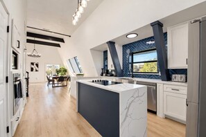 A modern kitchen with a central island, built-in appliances, and a dining area with natural light.