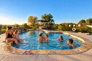 A swimming pool with a wooden deck surrounding it, a covered seating area, and a fence with a tire swing. - Modern Home - 1 Acre Lot w/ Pool, Patios, Jacuzzi (Denton)