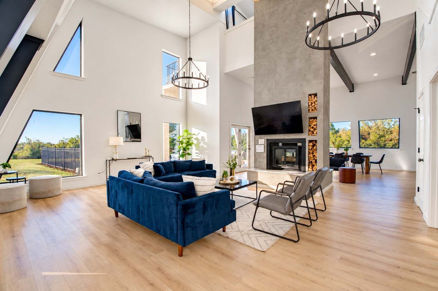 A spacious living room with a large blue sofa, a fireplace, and a TV.