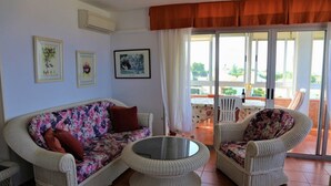 A living room with a sofa and chairs, a glass table, and a view of a patio with a table and chairs. - Penthouse-apartment mit 140 qm - Direkter Merresblick (Monte Faro)