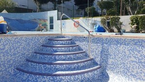 A swimming pool with a mosaic tile design and a metal staircase leading into the water. - Penthouse-apartment mit 140 qm - Direkter Merresblick (Monte Faro)