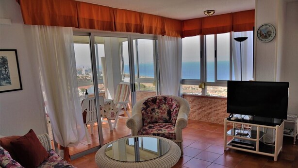 A living room with a sofa, armchair, and a TV on a stand. - Penthouse-apartment mit 140 qm - Direkter Merresblick (Monte Faro)