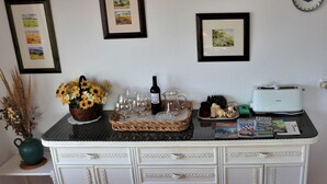 A kitchen counter with a wine bottle, glasses, a basket of flowers, and a toaster. - Penthouse-apartment mit 140 qm - Direkter Merresblick (Monte Faro)