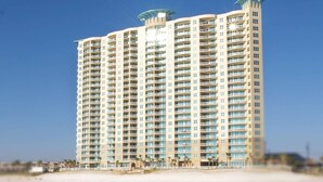 A high-rise hotel with multiple balconies, located near a beach. - Amazing 3 Bedroom 3 bath overlooking the breathtaking emerald coast water. (Panama City Beach)