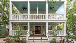 A two-story house with a porch, a flag, and a bicycle. - Private Pool,LSV/Golf Cart, & 6 Bikes! Steps to Seaside in the Heart of Old Seagrove! (Santa Rosa Beach)