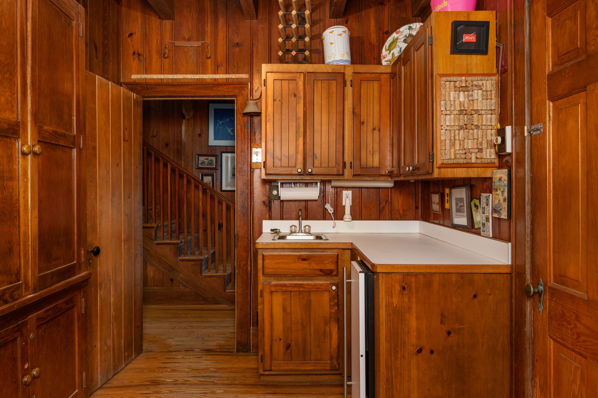 Eine Holz-Küche mit eingebautem Geschirrspüler, Holzschränken und einer weißen Arbeitsplatte.
