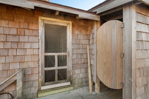 A wooden building with a large circular door and a window with a grid pattern.