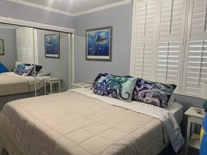 Relax in a serene space with a comfortable bed, bedside table, and mirror.