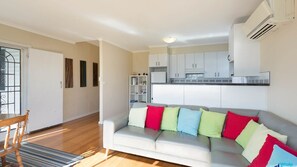 Relax in a comfortable living space with a sofa, dining table, and kitchen area.