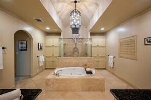 A spacious bathroom with a large bathtub, a chandelier, and a vanity with a mirror. - Best Location in Houston - Very spacious house - Close to everything (Houston)