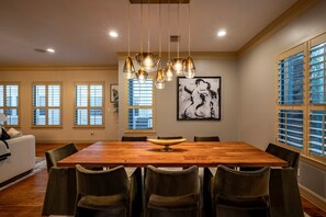 A dining area with a wooden table, six chairs, and a hanging light fixture. - Best Location in Houston - Very spacious house - Close to everything (Houston)