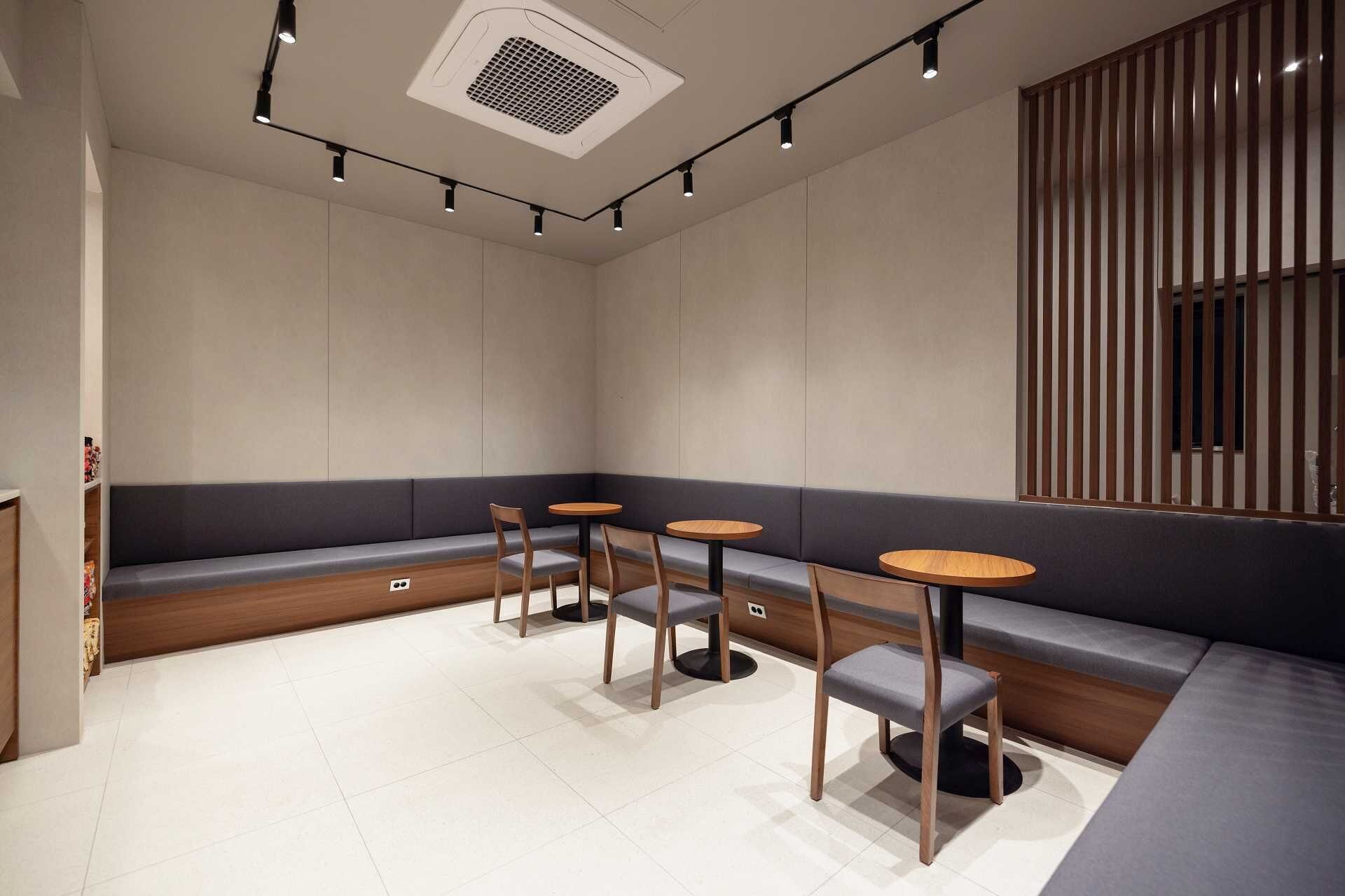 A modern interior with a seating area, tables, and a decorative wall panel.