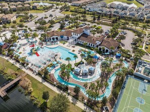 Vue aérienne d’un quartier résidentiel doté d’une grande piscine, de plusieurs courts de tennis et d’un club-house.
