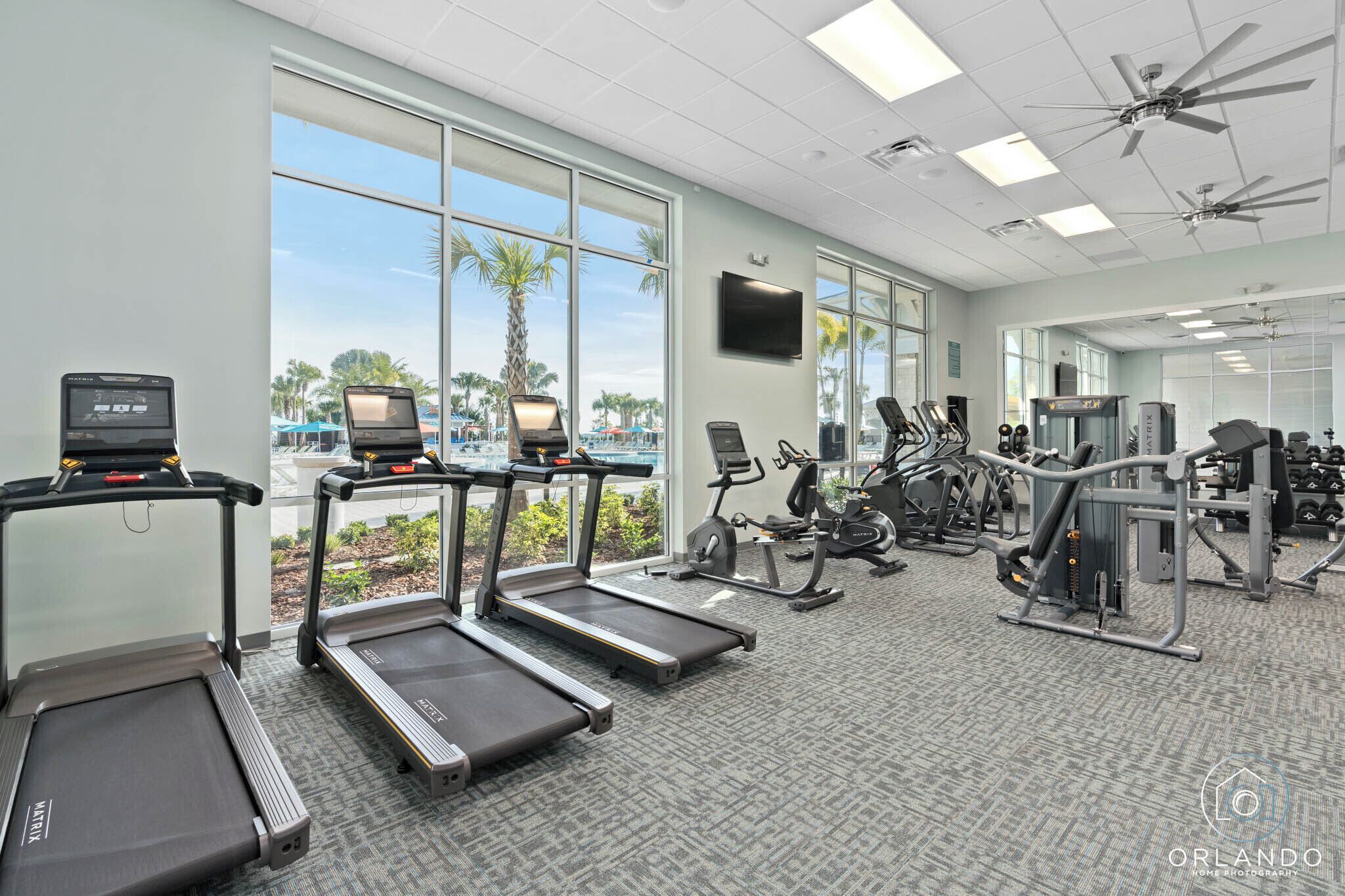 Une salle de sport équipée de tapis de course, de vélos d’exercice et d’appareils de musculation.