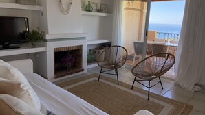 A modern living room with a fireplace, comfortable seating, and a balcony with a view of the sea. - Fantastic views , sun and relax at Altea Hills Charming house Costa Blanca (Altea Hills)