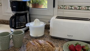 A kitchen counter with a coffee maker, toaster, bread, and strawberries. - Fantastic views , sun and relax at Altea Hills Charming house Costa Blanca (Altea Hills)