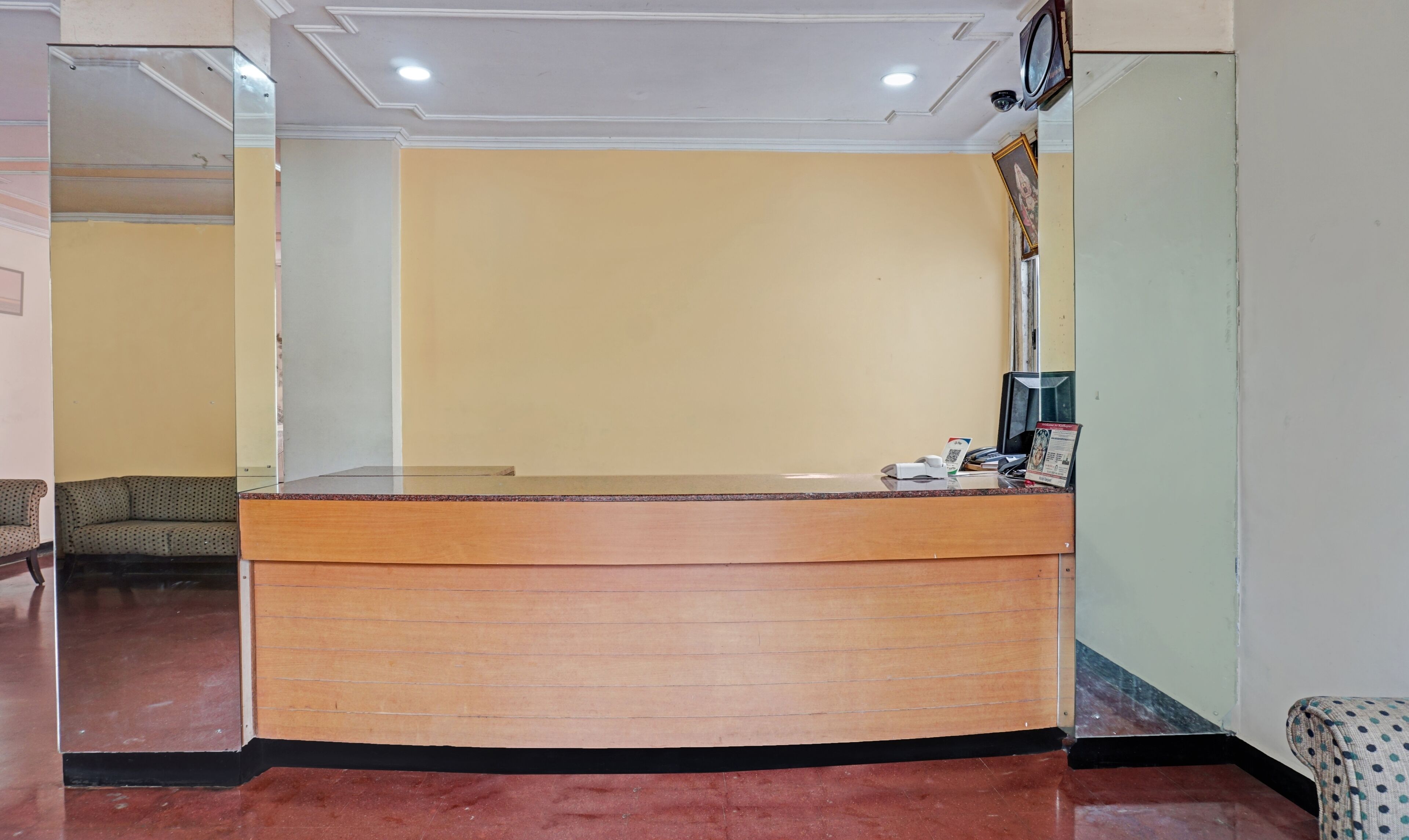 A reception desk with a wooden counter and a glass partition.