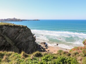 Eine Küstenlandschaft mit Klippe, Strand und Meer.