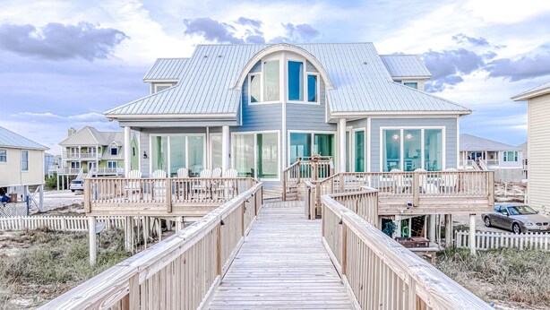 A large house with a covered porch and a wooden deck leading to the entrance. - Beachfront in Morgantown (Gulf Shores)