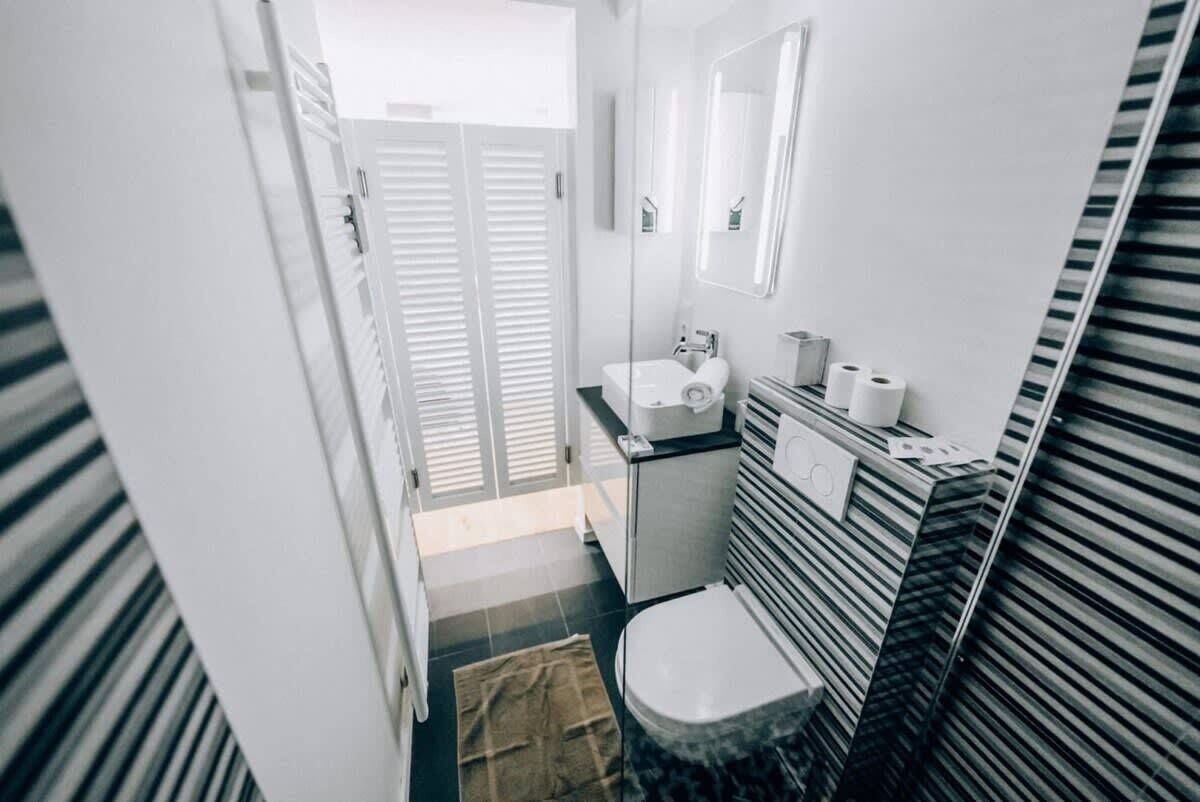 Un baño pequeño con inodoro, lavamanos y espejo.