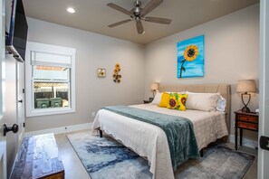 Relax in this serene bedroom with a large bed, nightstands, and a ceiling fan.