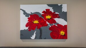 A painting of red flowers on a wall.
