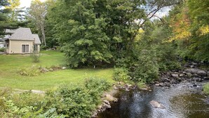 A house with a yard and a stream. - The Riverfront Retreat- 27 minutes to Sugarloaf! (New Portland)