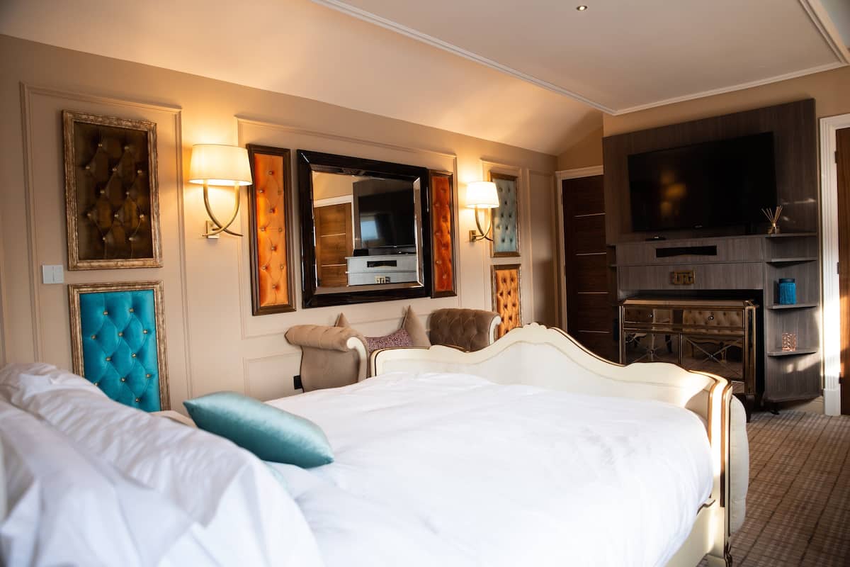 Une chambre d’hôtel avec un grand lit, une télévision et un mini-bar.