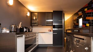 A modern kitchen with stainless steel appliances, a central island, and a tiled backsplash.