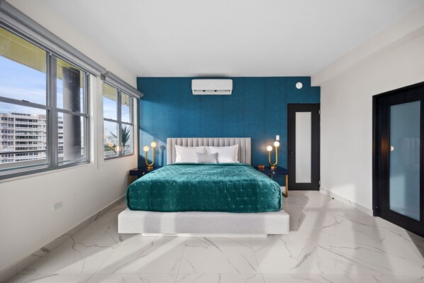 A modern bedroom with a bed, large windows, and a city view. - Don Rafa Boutique Hotel & Residences (San Juan)