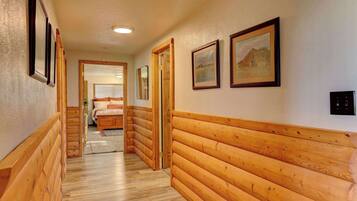 A hallway with wooden paneling and framed pictures on the walls.
