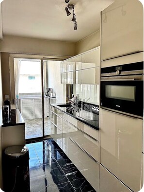 A modern kitchen with a built-in oven, a microwave, and a large window. - Croisette Bijou Plage Gorgeous  apartment amazing seaview,  beaches all around (Cannes)