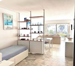 A modern living room with a convertible sofa bed, a dining area, and a balcony with a view. - Croisette Bijou Plage Gorgeous  apartment amazing seaview,  beaches all around (Cannes)