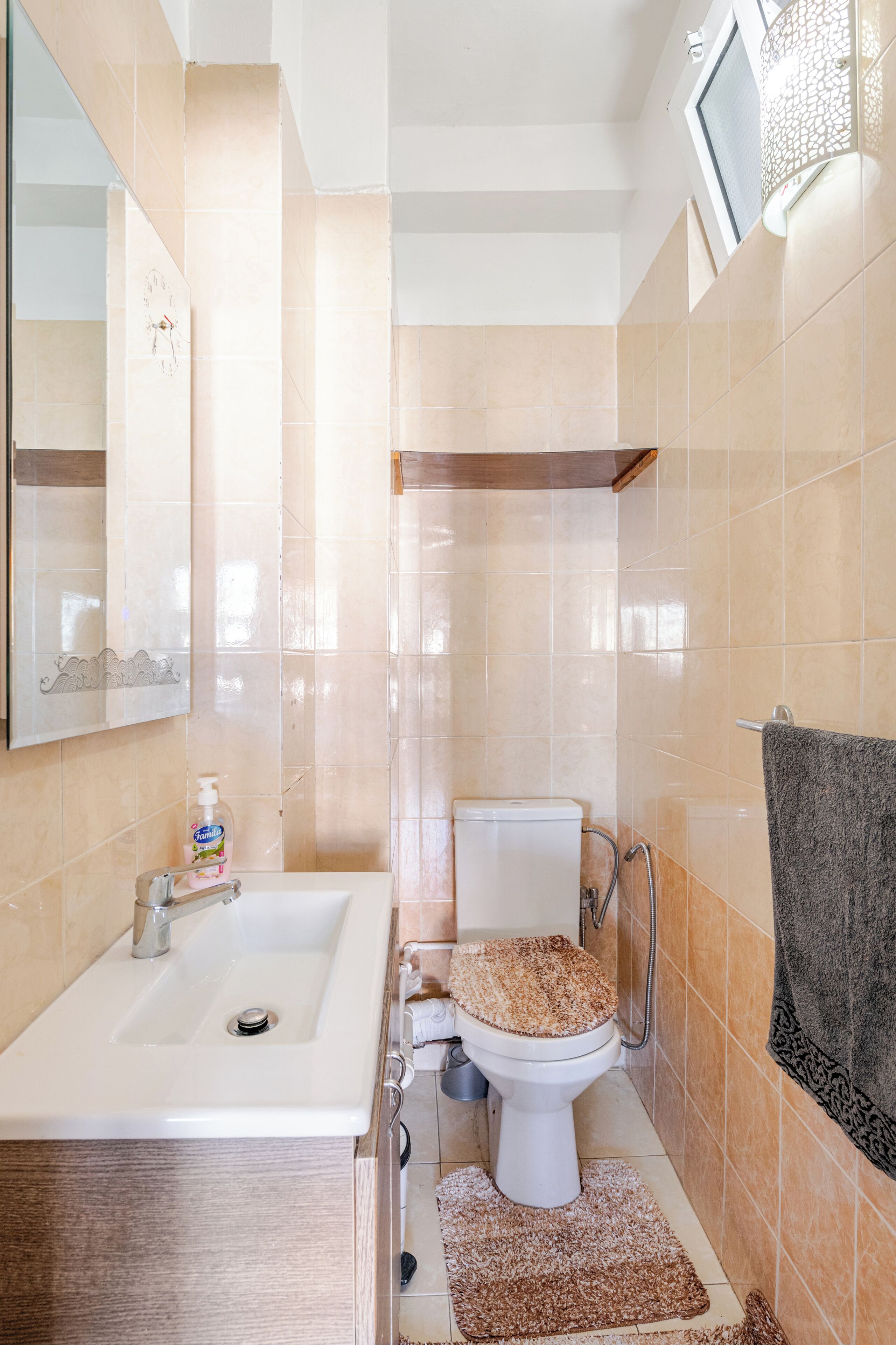 Une salle de bain avec un lavabo, des toilettes et un miroir.
