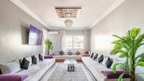 Una sala moderna con un conjunto de sofá, una mesita de centro y un ventanal con cortinas.