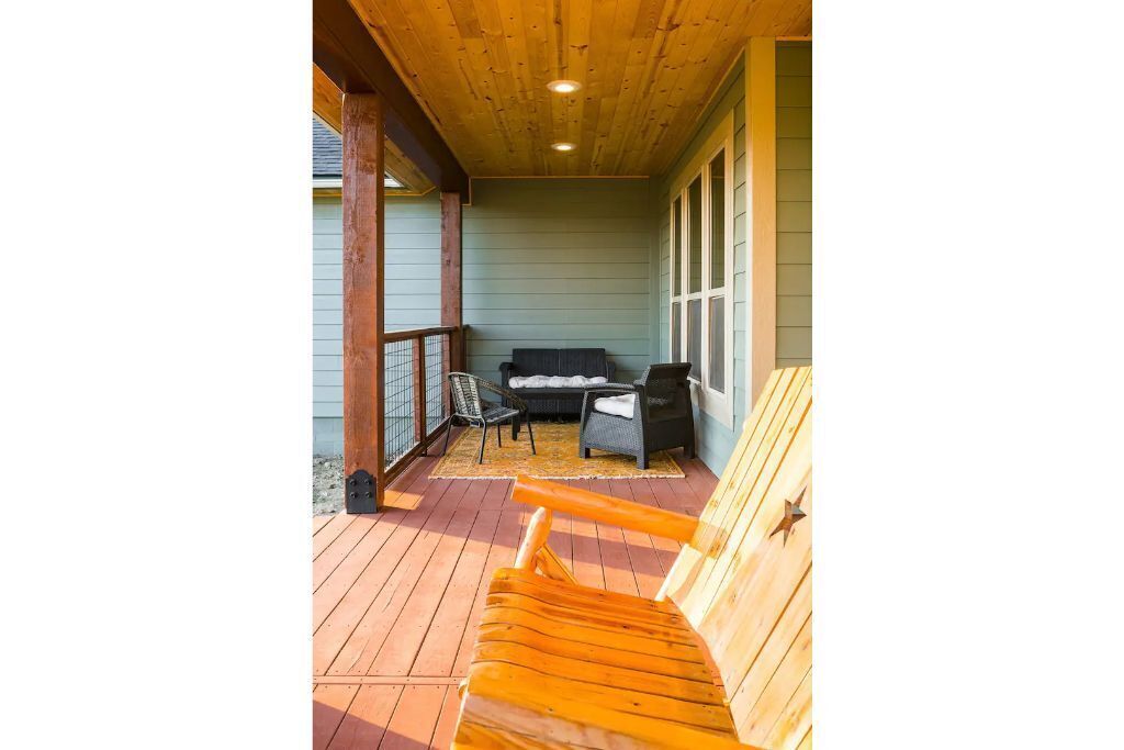 Une terrasse en bois avec un banc, une petite table et un canapé.