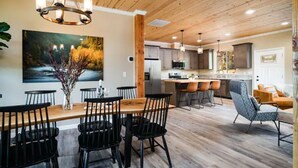Una cocina moderna con armarios de madera, una isla central e iluminación colgante.