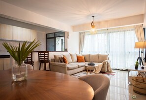 Relax in this inviting living space with a comfortable sofa, dining table, and natural light pouring in through the large window.