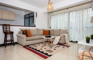 Relax in this inviting living space with a comfortable sofa, a wooden chair, and a small table for unwinding.