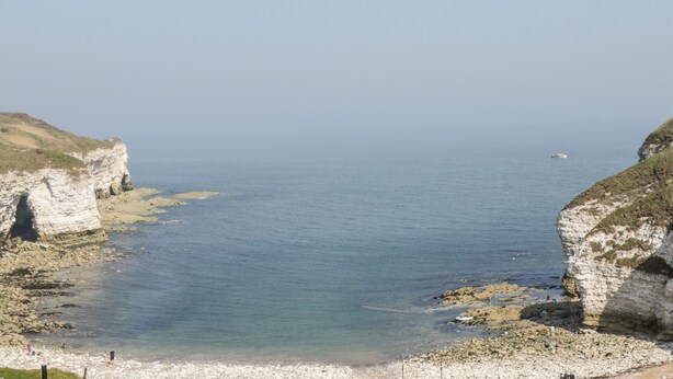 A coastal scene with cliffs and a beach. - Bluebell Cottage (Bridlington)