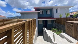 A modern two-story house with a red roof, white walls, and a balcony. - Bwa Flote' (Les Trois-Îlets)