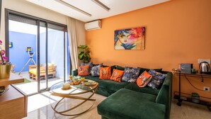A modern living room with a green sofa, a round coffee table, and a painting on the wall. - Majorelle - Daily rental Casablanca (Casablanca)