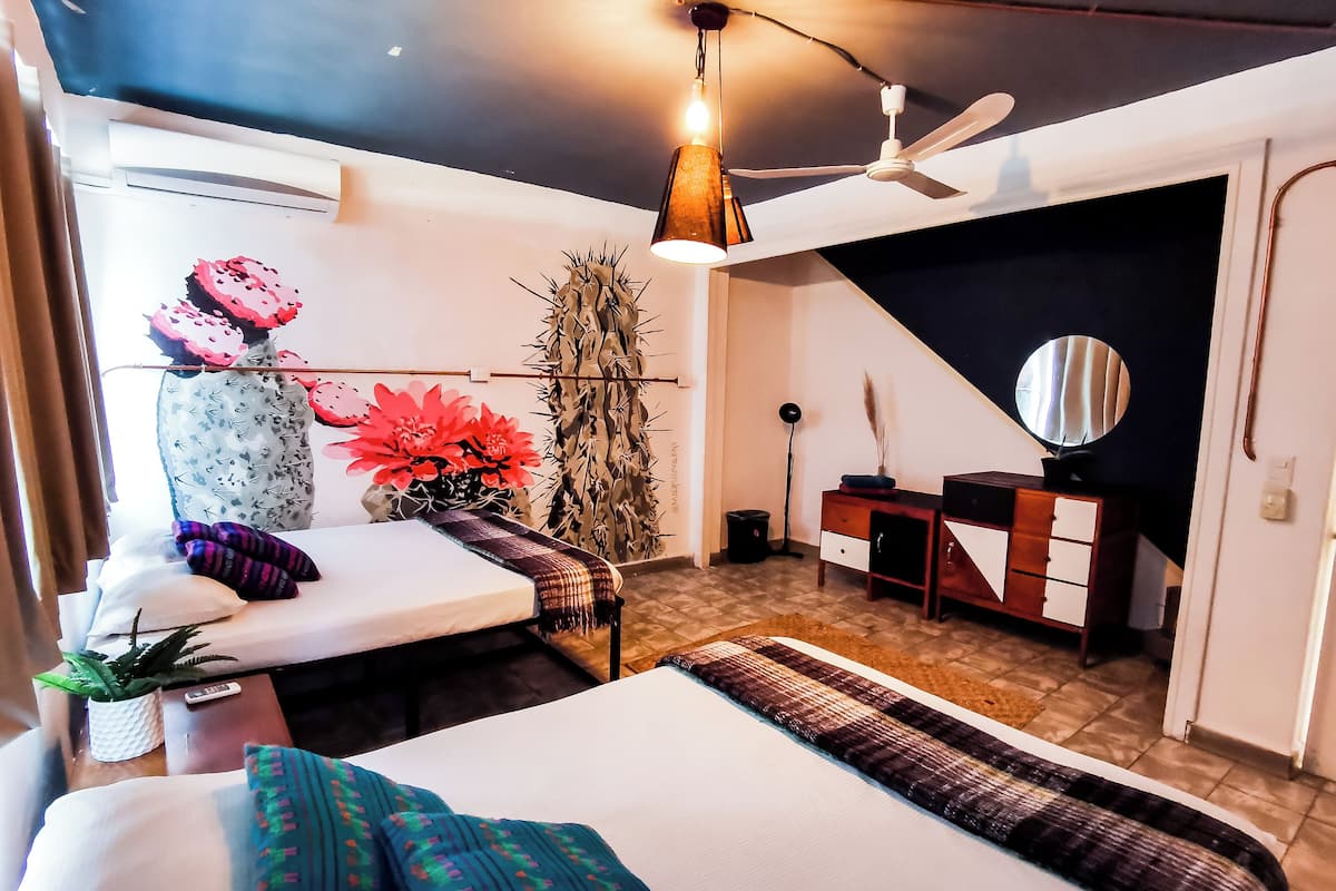 Un dormitorio moderno con cama, mesita de noche, cómoda y ventilador de techo.