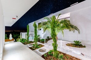 A modern outdoor space with a starry sky ceiling, palm trees, and a white building. - Luxury Villa Complex VITAE & PAX (Sutivan)