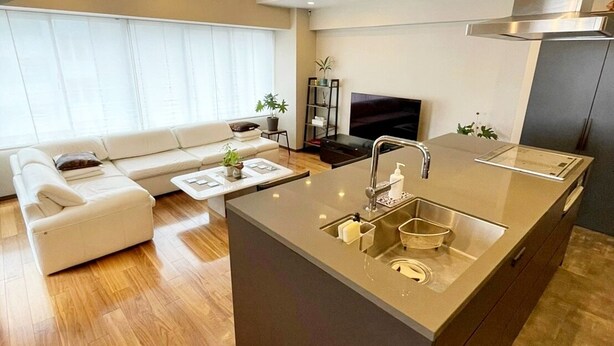 A modern kitchen with a central island, built-in appliances, and a dining area with a sofa and coffee table. - Residenza La Giacca (Tokyo)